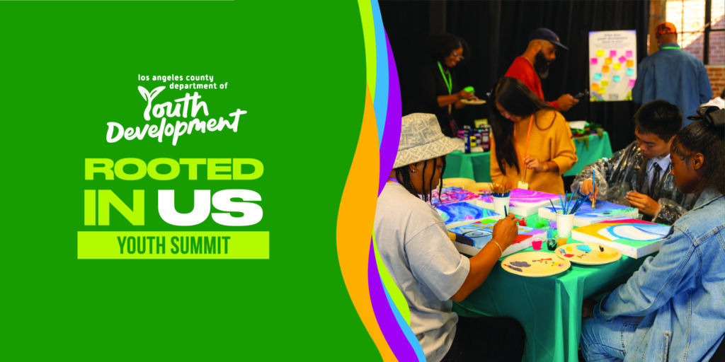 Promotional image for the Los Angeles County Department of Youth Development&rsquo;s 'Rooted in Us' Youth Summit. The left side has a bright green background with the event title in white and lime green text. The right side shows a group of young people seated at tables painting colorful art pieces, with brushes, paint palettes, and canvases on teal tablecloths. A facilitator and other participants are visible in the background.